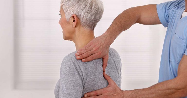 Mature woman having chiropractic back adjustment
